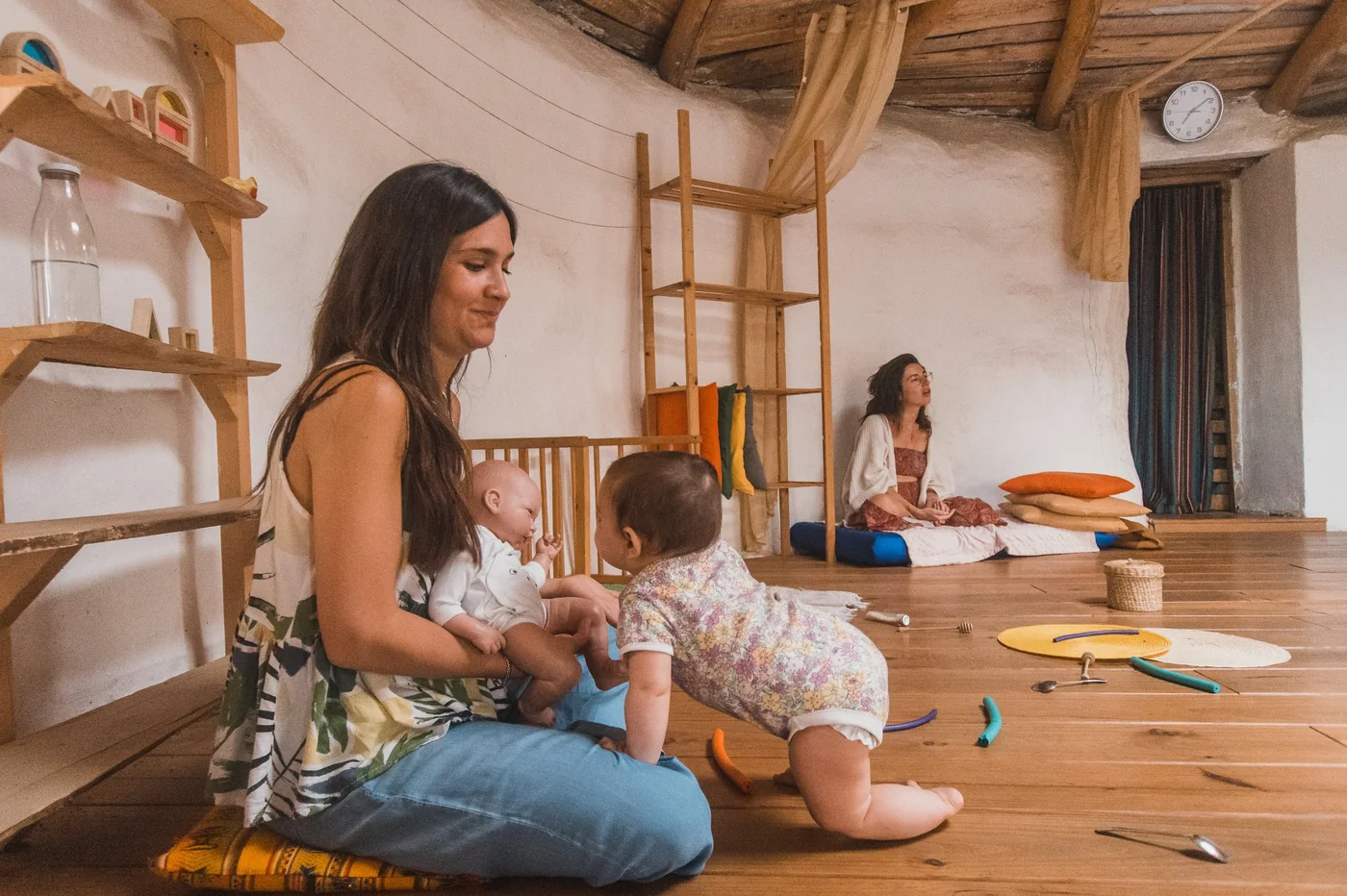 Faus Antunes en la sala con dos bebés y otra adulta acompañando al fondo
